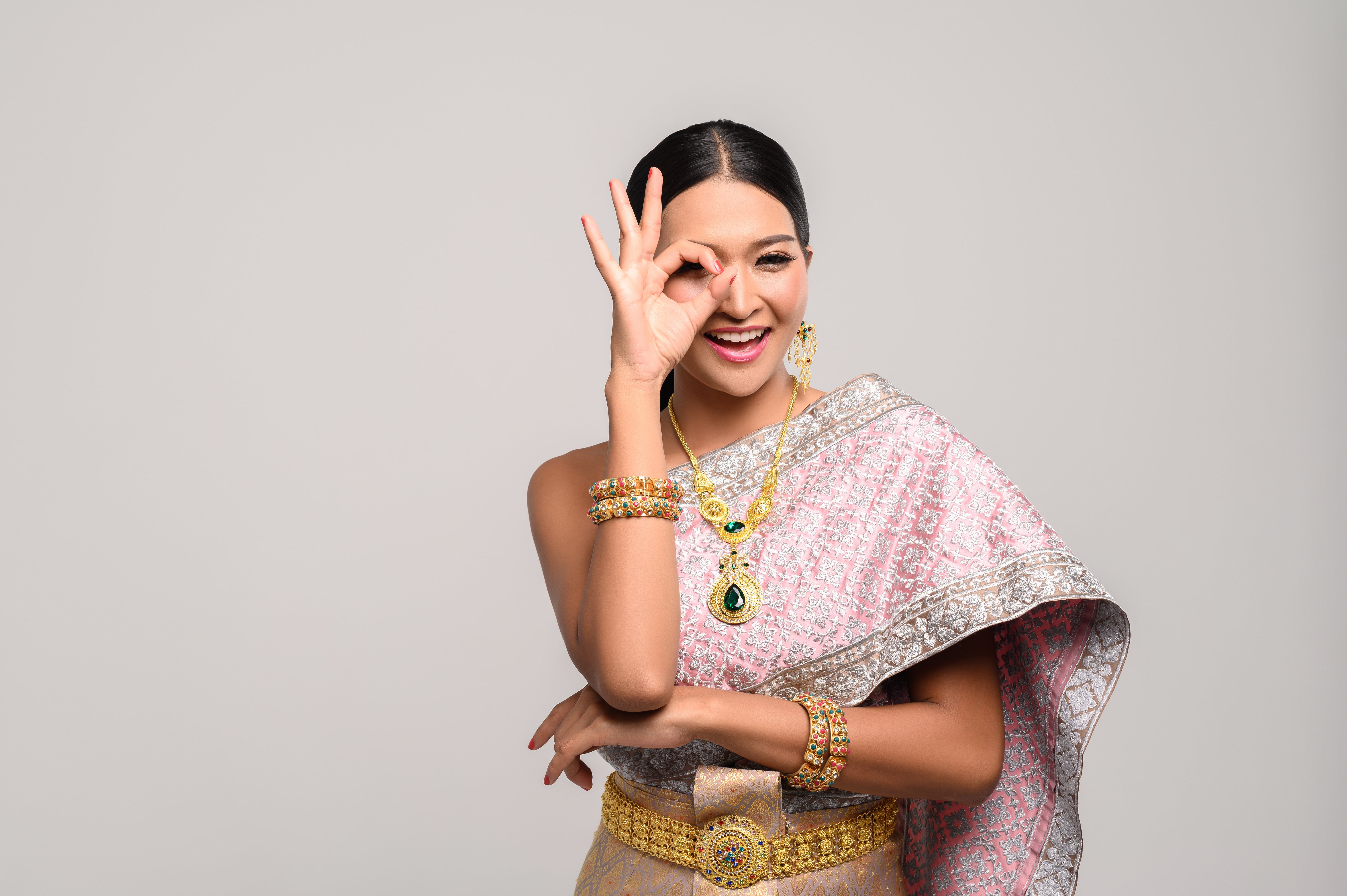 woman wearing thai clothes hand symbolizing ok