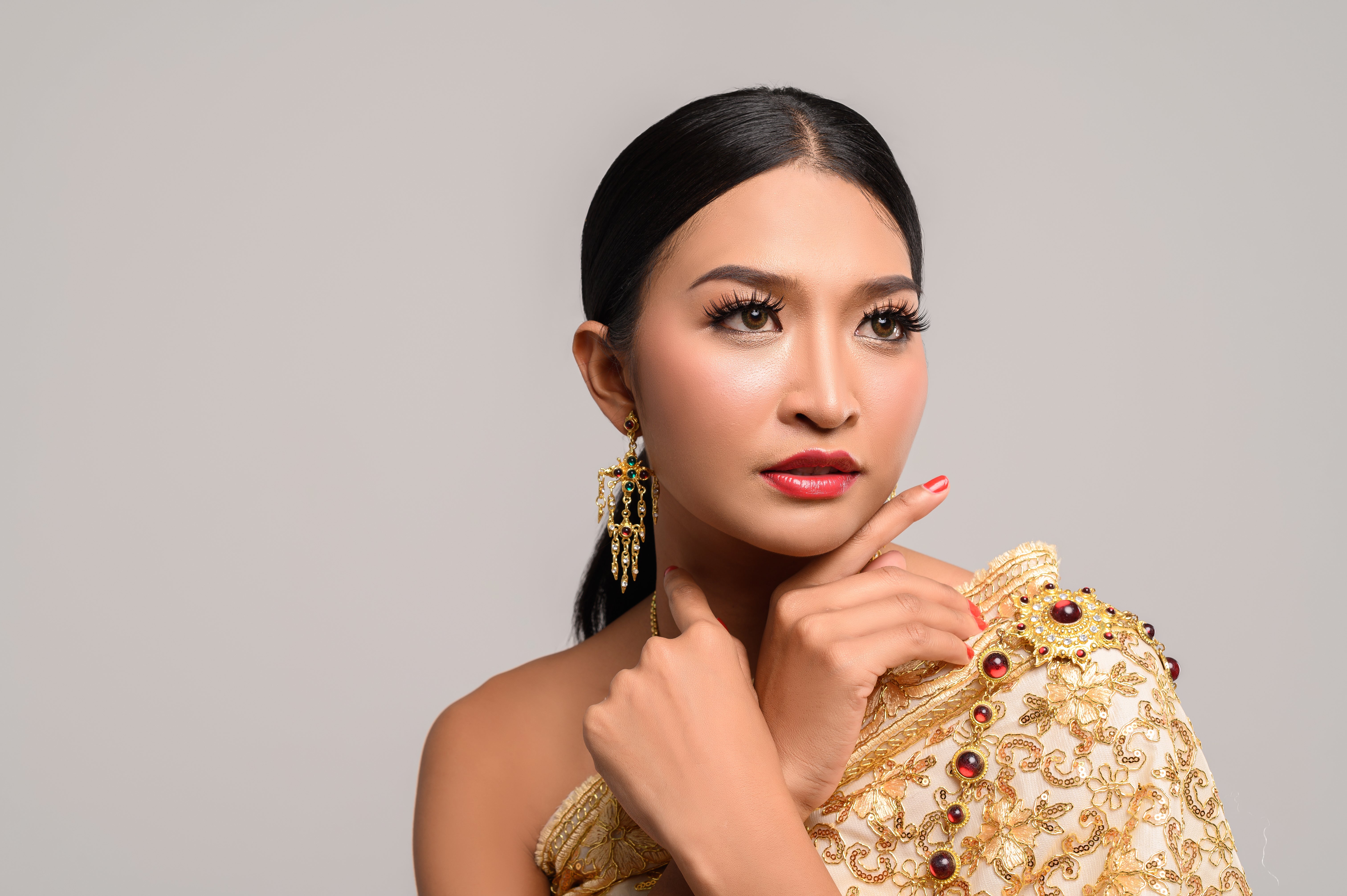 woman wearing thai clothes hands touching her face